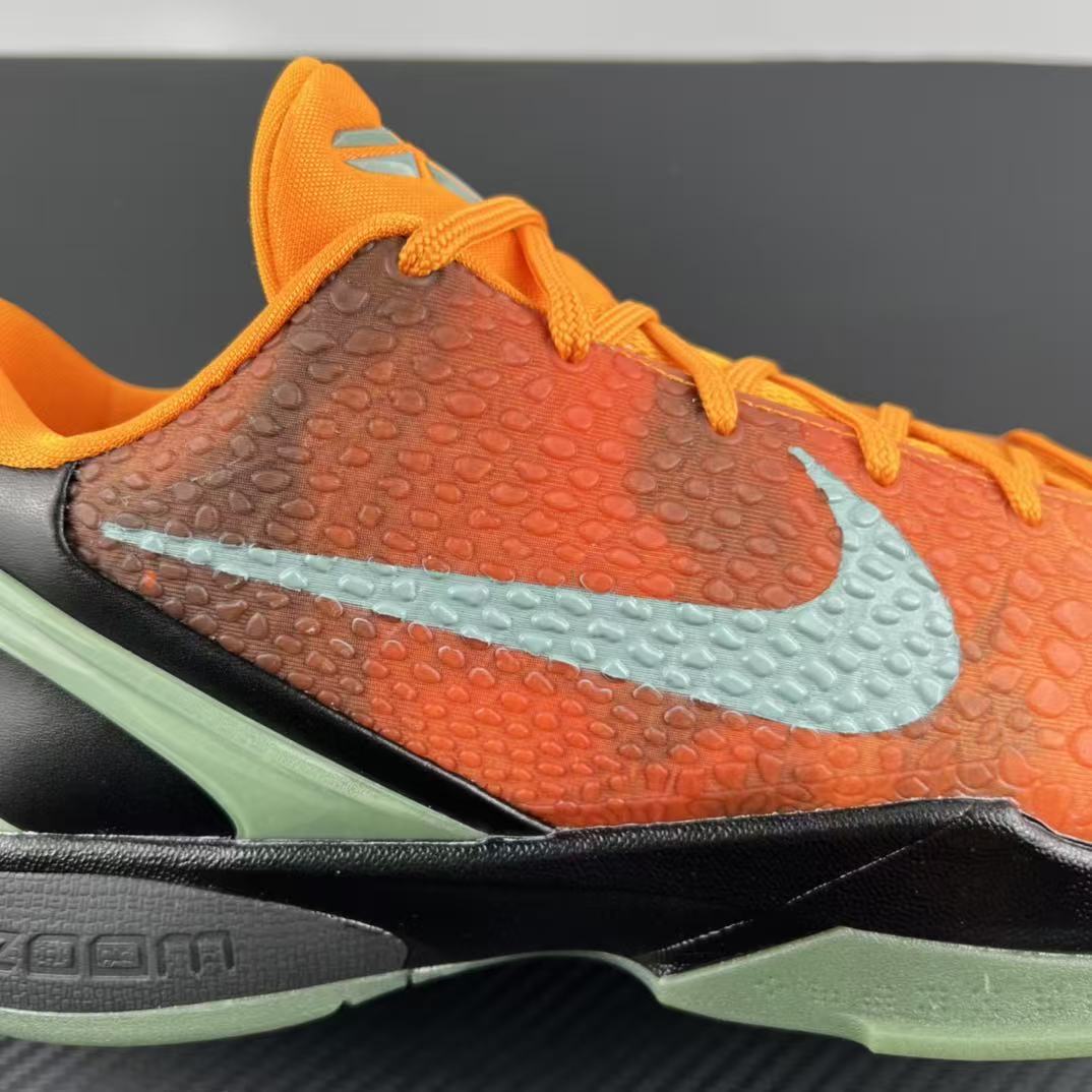 Basketball shoe side with light blue swoosh, orange upper, and green sole
