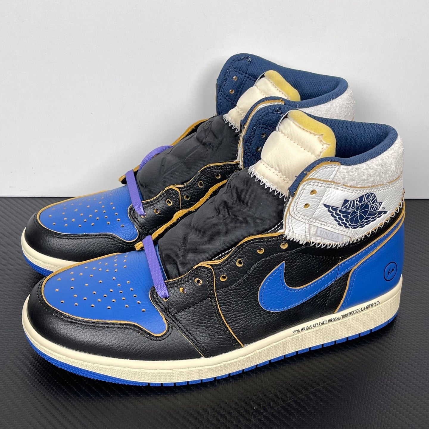 High-top sneakers pair angled view with black leather, blue panels, white collar, purple lace
