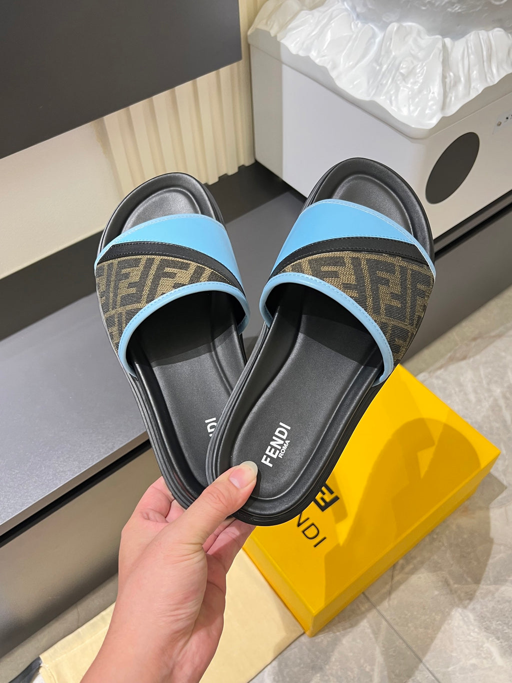 Fendi slide sandals: light blue strap with brown FF pattern on black footbed
