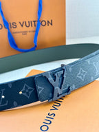 Louis Vuitton belt close-up: dark monogram strap with silver-tone LV buckle and keeper.