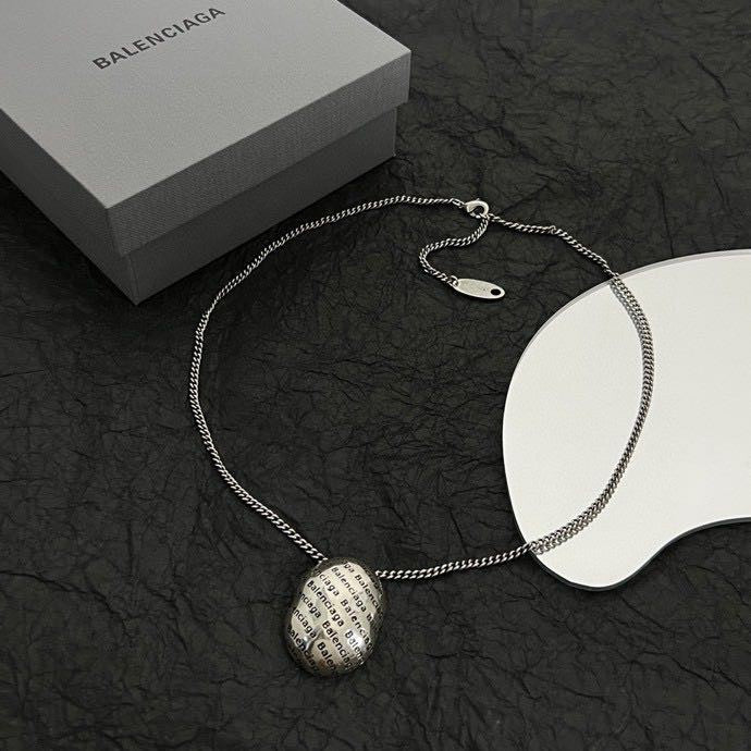 Silver-tone chain necklace with round logo pendant and oval tag charm