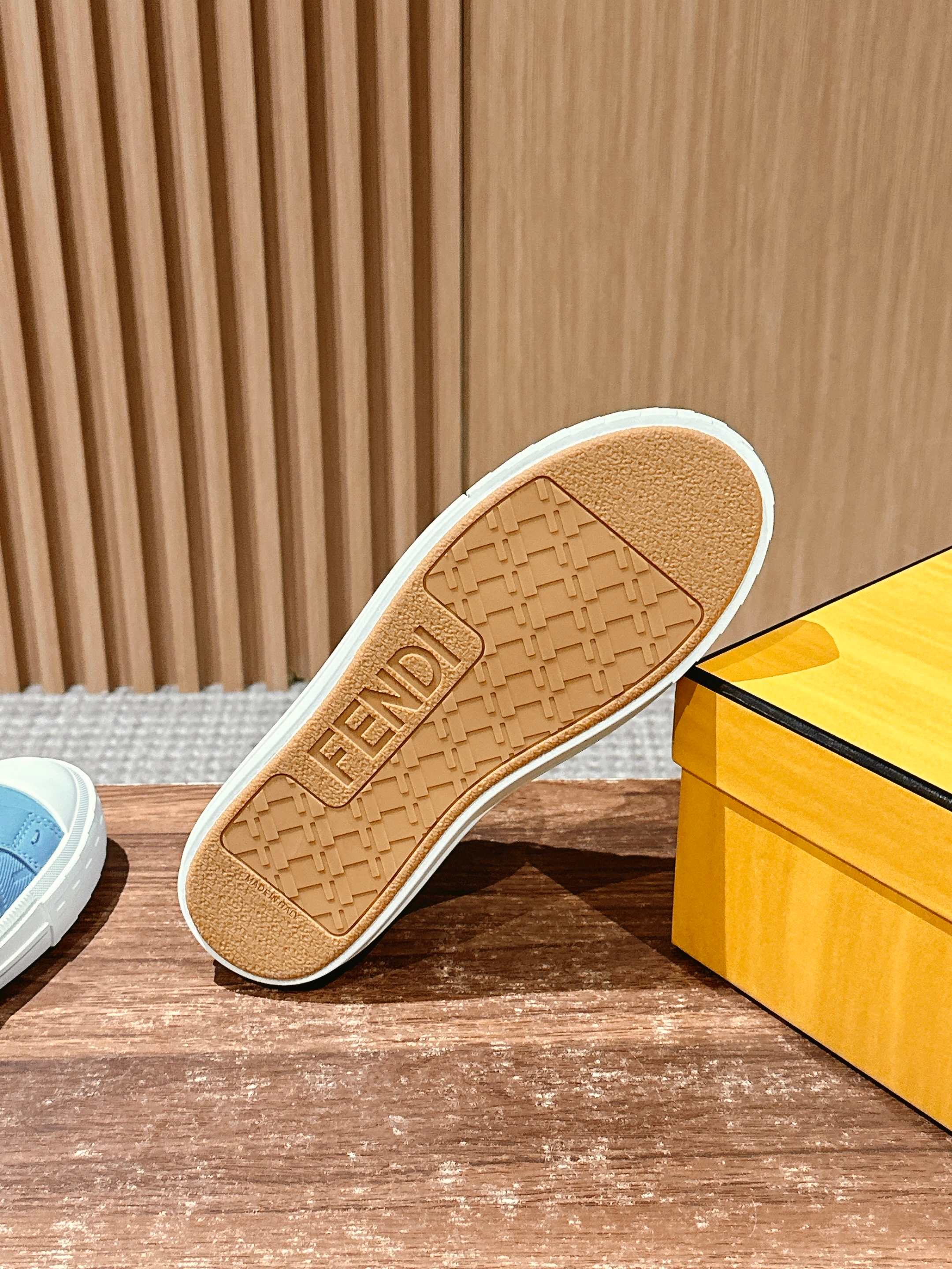 Light blue sneaker outsole with FENDI embossing on tan rubber tread.