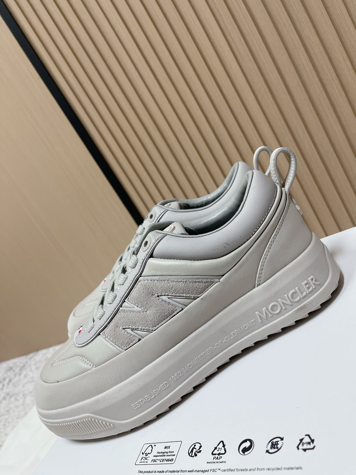 Light gray low-top sneakers with lace-up closure and Moncler branding on side