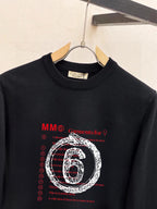 Black crewneck sweatshirt with long sleeves and “6” graphic logo print, close up
