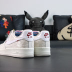 White Air Force 1 low sneakers with Nike Air heel tabs and red swoosh