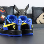 Nike Air Force 1 low-top sneakers, blue and black with yellow accents; heel detail view.