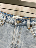 Maison Margiela denim jeans waistband close-up with engraved logo patch and belt loops
