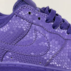 Purple low-top sneakers with lace-up closure, stitched panels, and textured finish