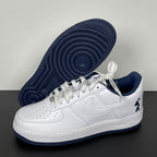 White Nike Air Force 1 sneaker with navy outsole and lace-up upper