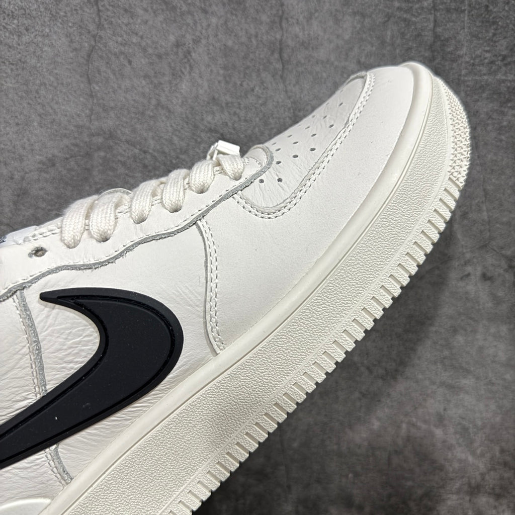 White leather sneaker toe and side with black swoosh and perforated detail