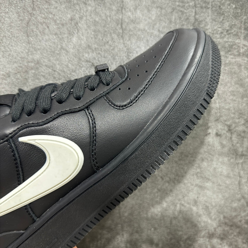 Black leather sneaker side panel with white Nike swoosh and perforated toe area