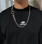 Balenciaga chain necklace with ring key charm and logo charm on black shirt