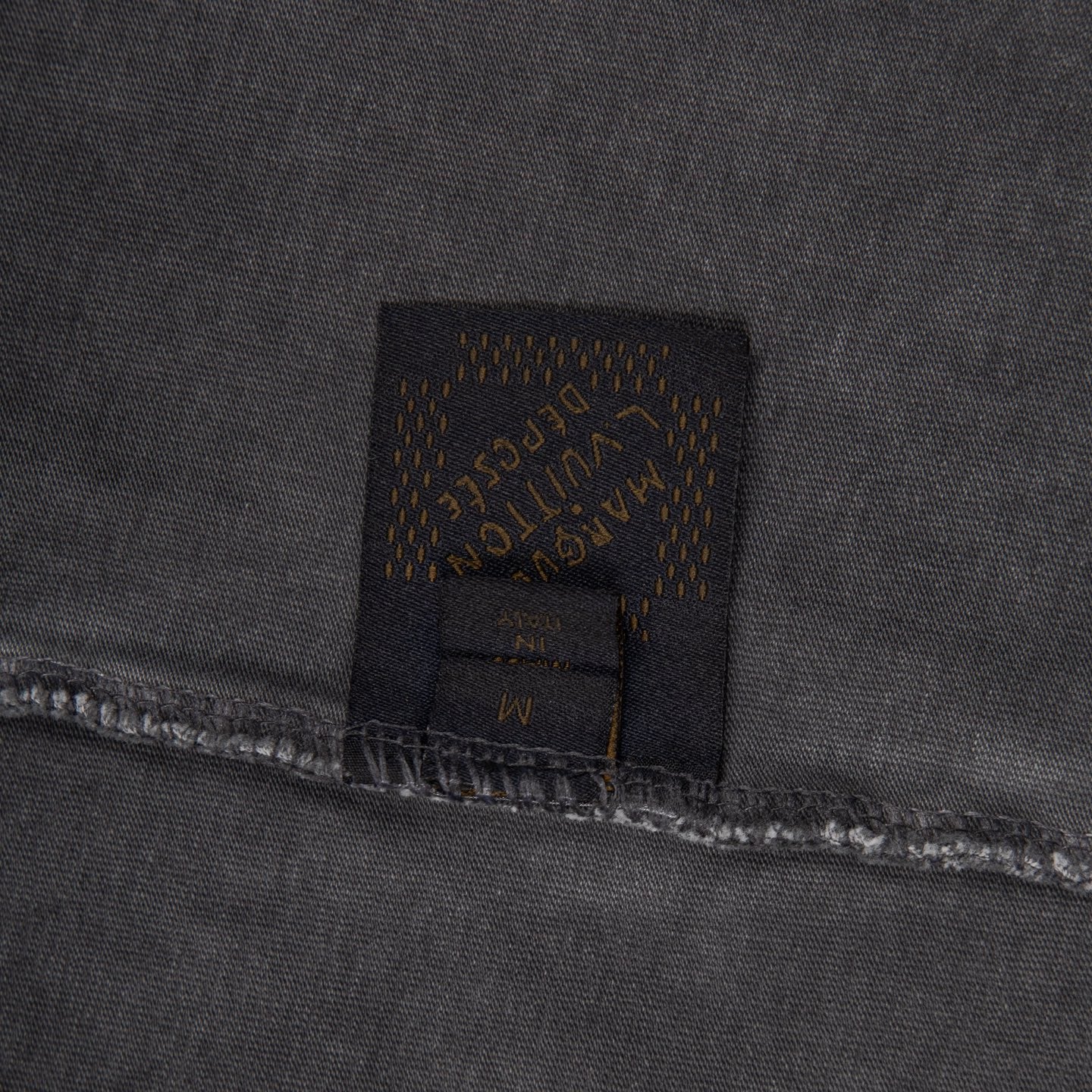 Dark fabric patch with Louis Vuitton label and visible stitching