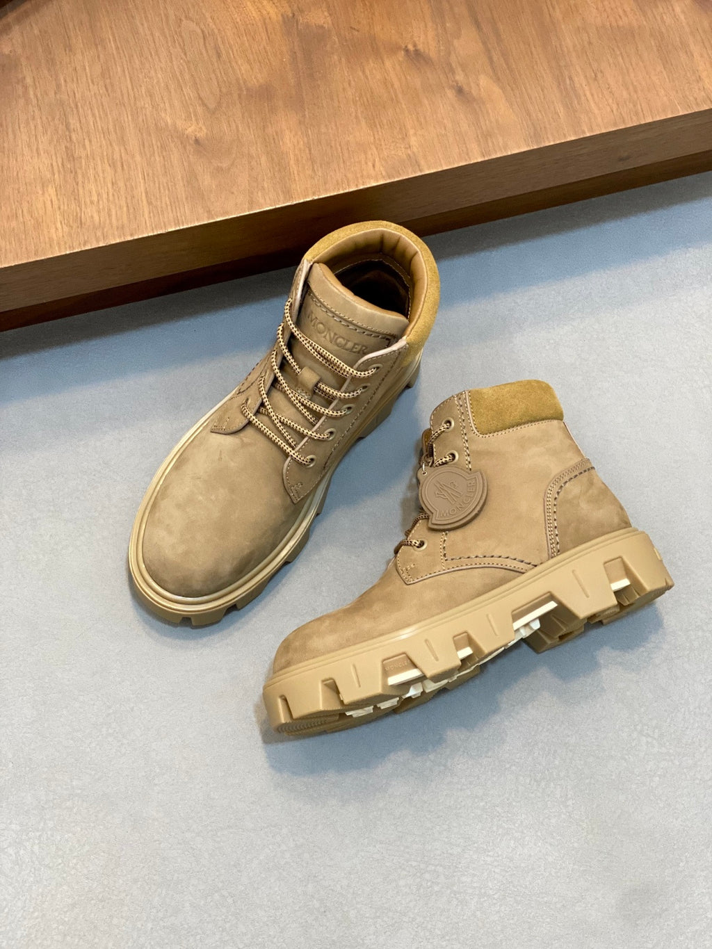 Pair of suede lace-up ankle boots with tan laces and rubber tread soles.