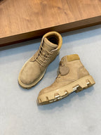 Pair of suede lace-up ankle boots with tan laces and rubber tread soles.