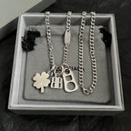 Balenciaga silver pendant necklace with clover, BB, and keyhole charms in box