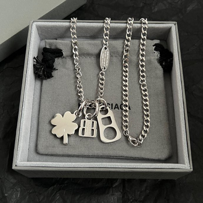 Balenciaga silver pendant necklace with clover, BB, and keyhole charms in box