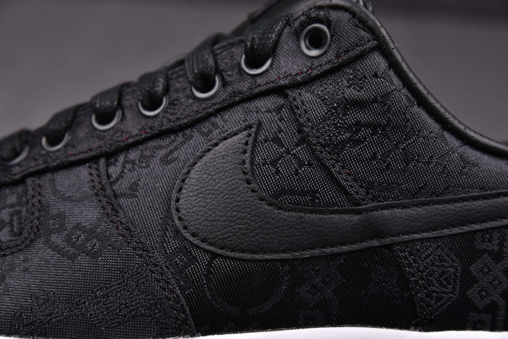 Black low-top sneakers with textured pattern, padded collar, and black Swoosh