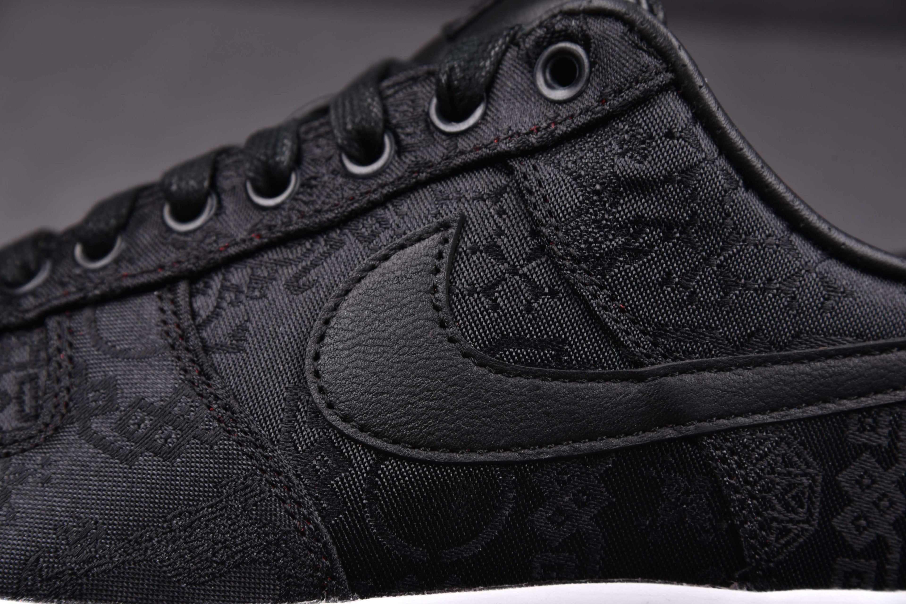 Black low-top sneakers with textured pattern, padded collar, and black Swoosh