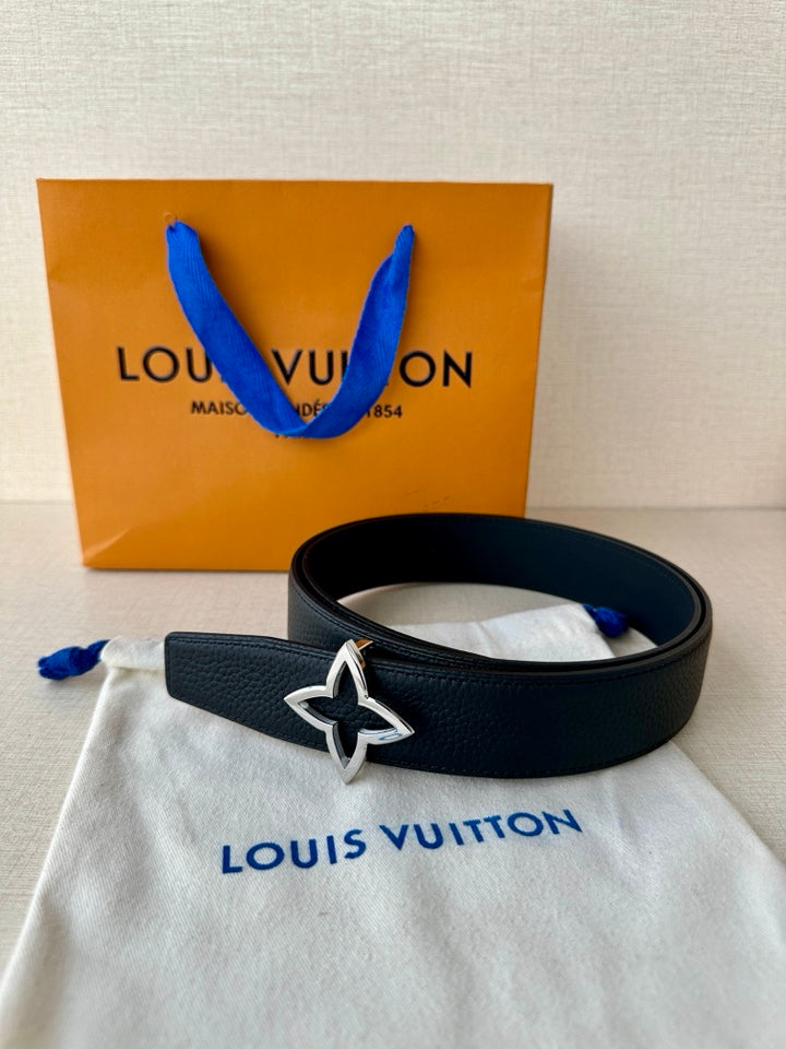 Navy leather belt with star emblem buckle, styled with gift bag and tissue