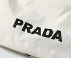 White jacket fabric close-up with large black PRADA lettering