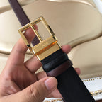 Leather belt buckle close-up, gold hardware on black textured strap