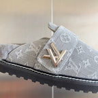 Louis Vuitton slide sandal close-up: gold V buckle on gray monogram strap