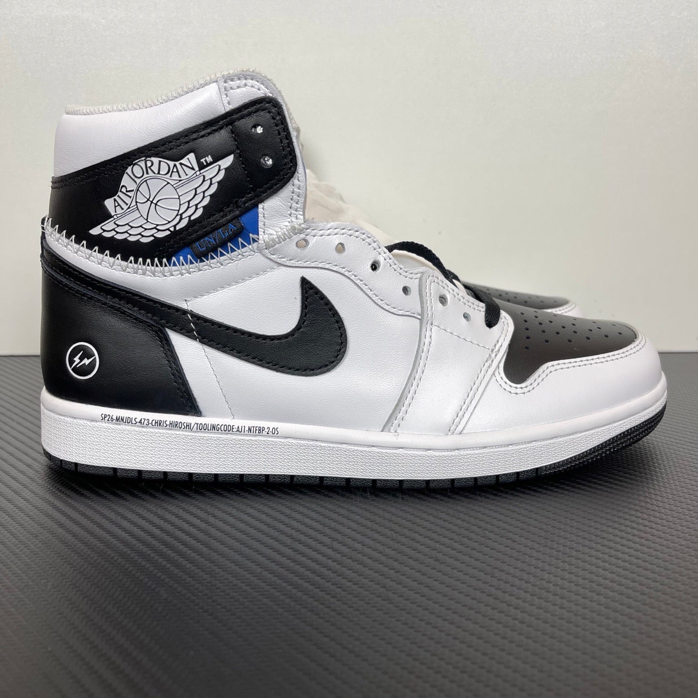 White and black high-top sneakers with black Nike Swoosh and wing logo on collar