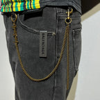 Balenciaga gold logo chain accessory with ring clip on dark jeans