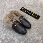 Gucci black slip-on shoes with plush faux fur collar and gold bit detail