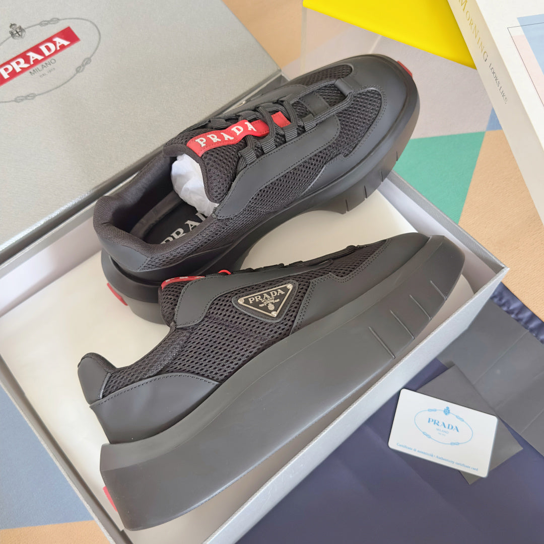 Prada unisex sneakers pair, dark gray perforated mesh, red accent details on sole