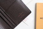 Louis Vuitton small wallet front panel with embossed logo and dark textured leather