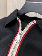 Black polo shirt with red-and-white striped double-zip detail.