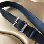 Prada belt with dark textured strap, silver buckle and leather keeper, side view