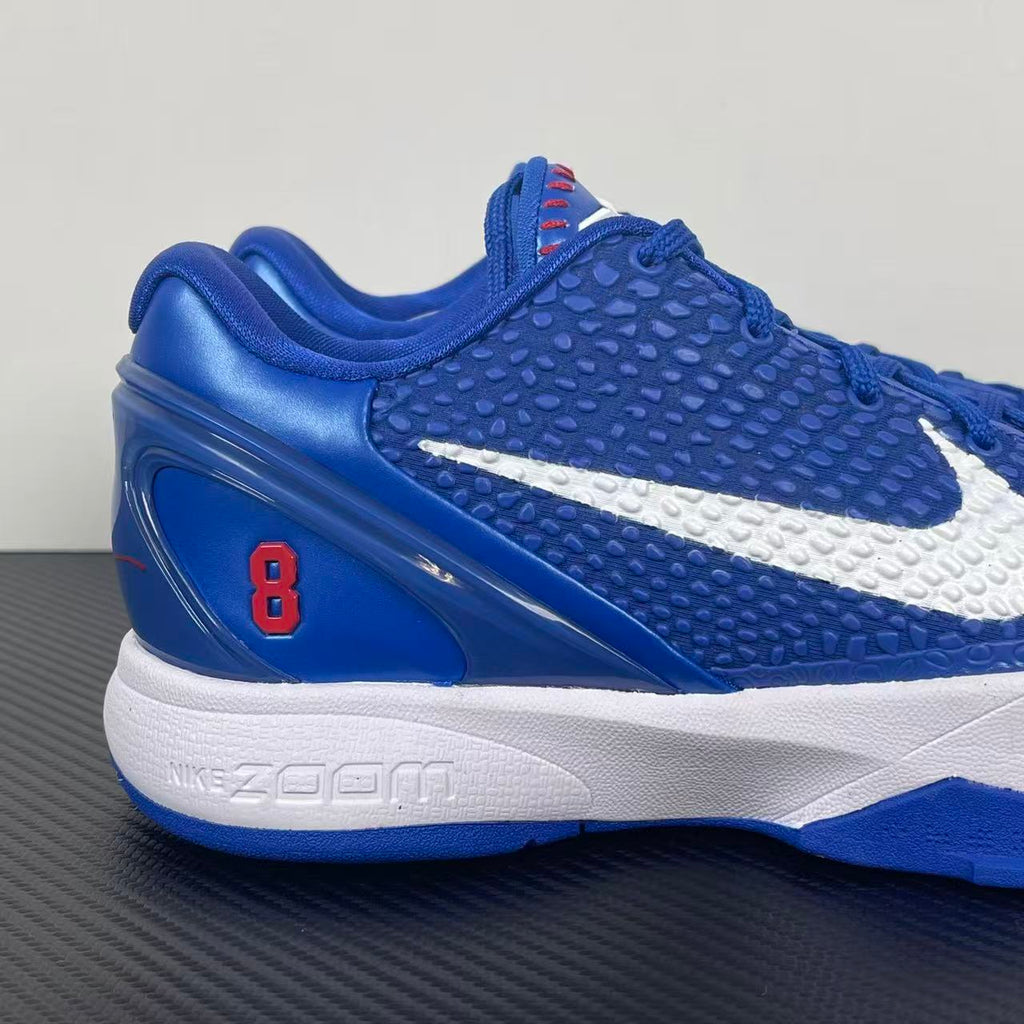 Blue Nike basketball sneaker with white swoosh, red accent, and cushioned sole