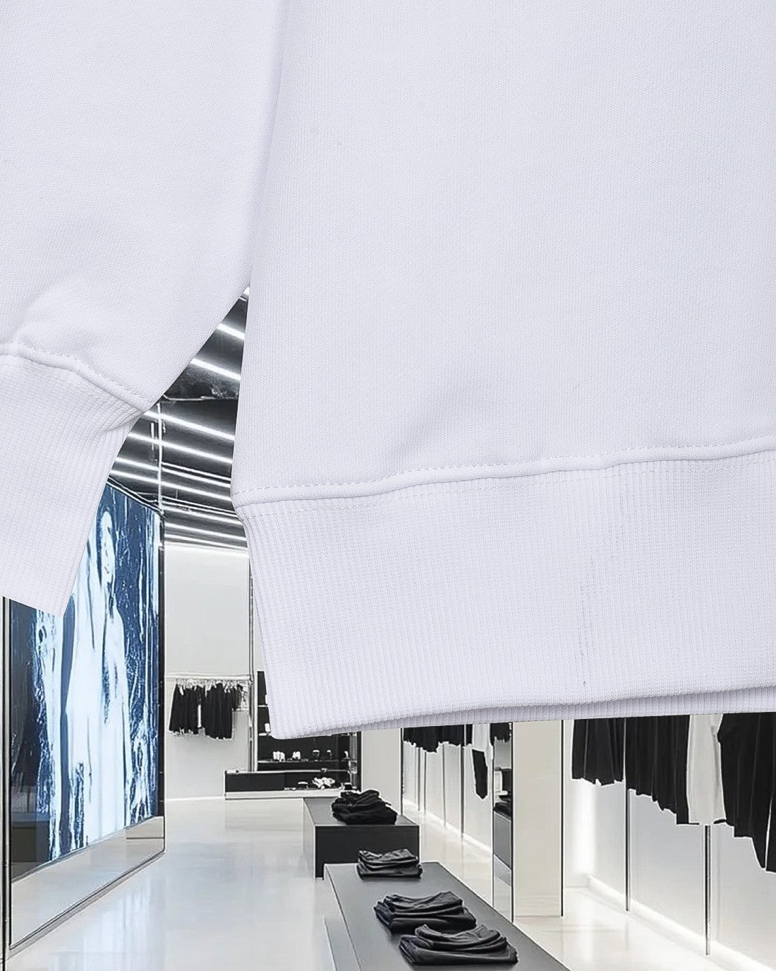 White sweatshirt lower hem with ribbed cuff detail and visible stitching