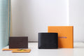 Black Louis Vuitton small bag wallet with LV logo on front, textured finish