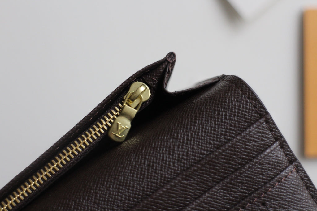 Louis Vuitton small wallet corner with gold zipper hardware and dark textured leather