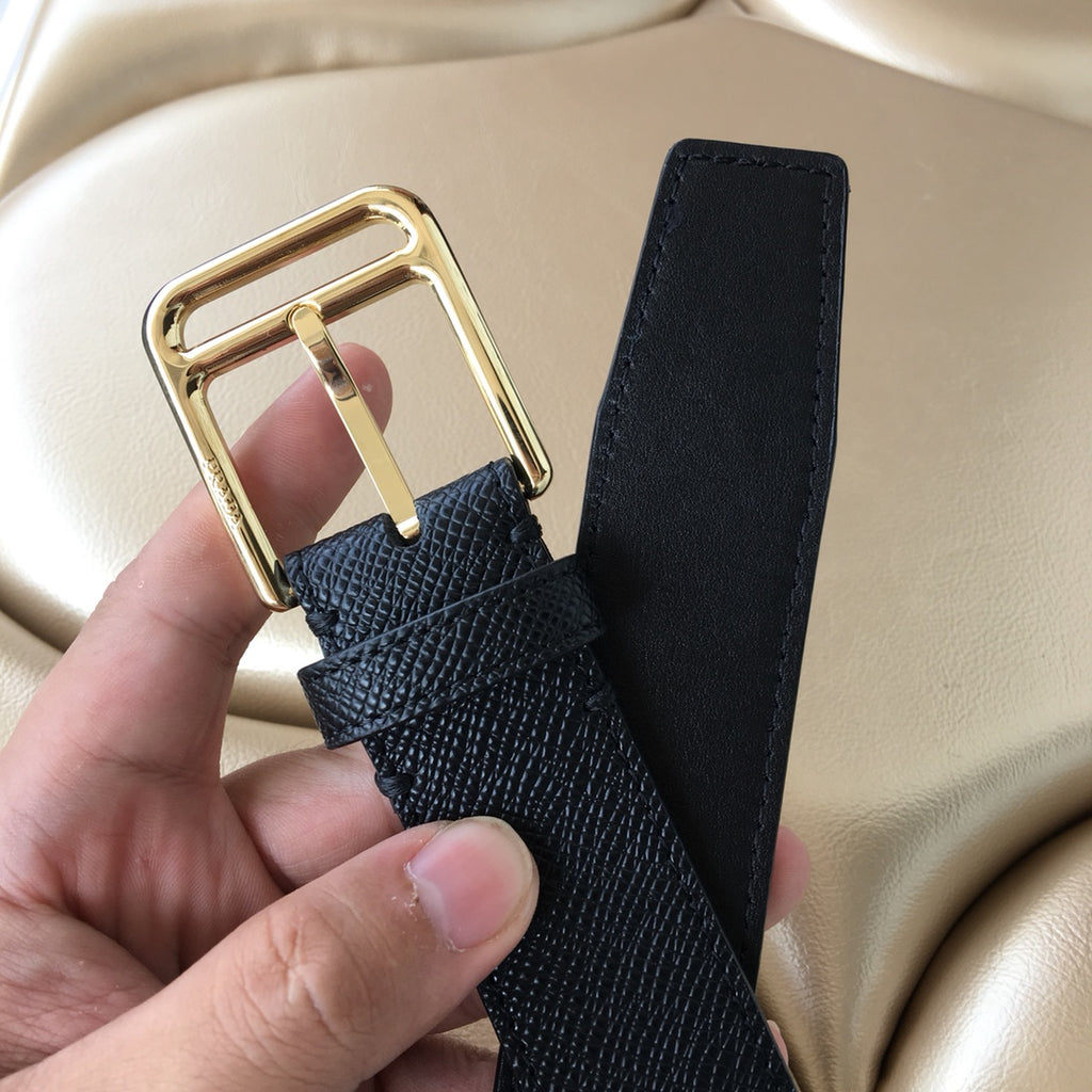 Dark textured leather belt with gold buckle and long strap end