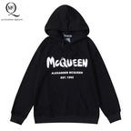 Black pullover hoodie with McQueen lettering and Alexander McQueen logo on chest.