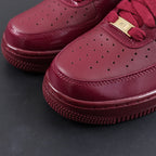 Burgundy sneaker toe box with perforations and lace eyelets, close-up