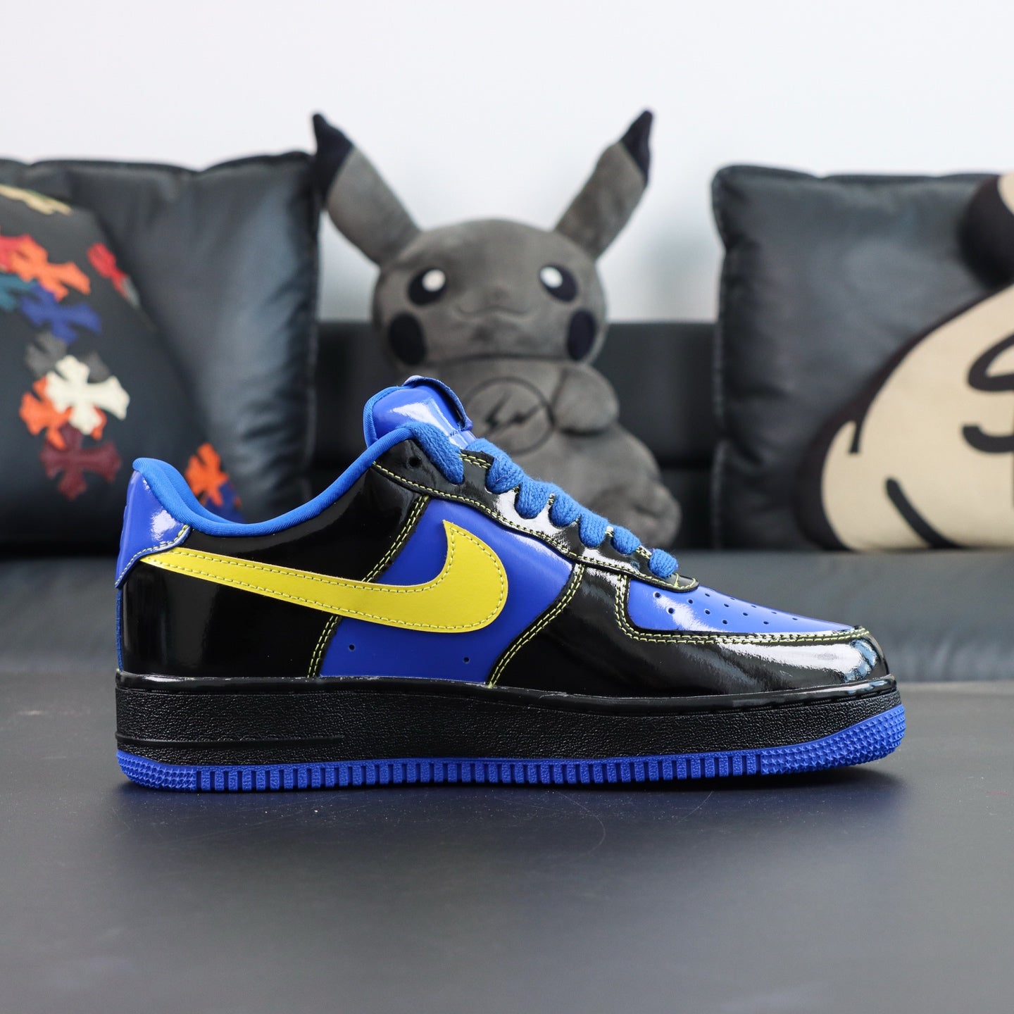 Nike Air Force 1 low-top sneakers, blue and black with yellow Swoosh; side profile view.