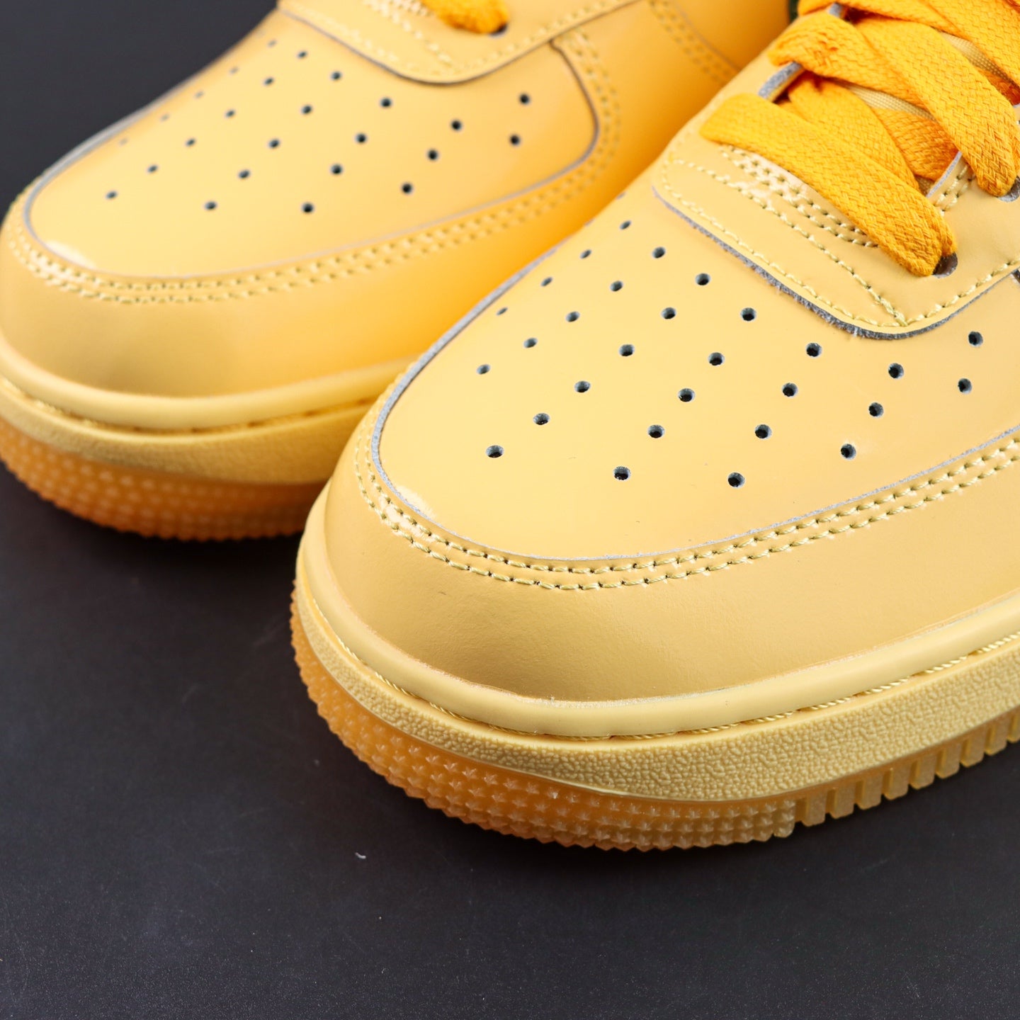 Nike Air Force 1 sneakers, yellow leather with perforated toe and orange laces