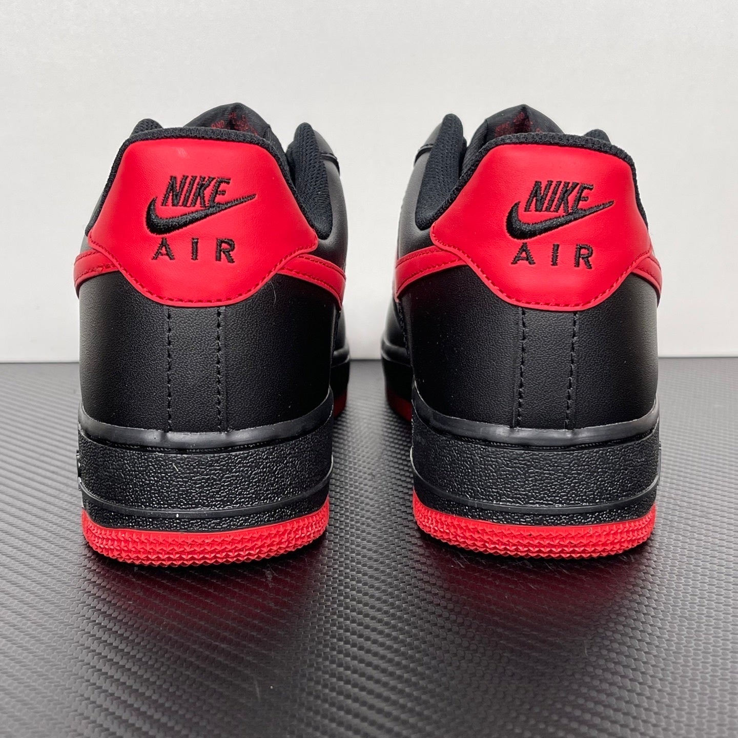 Black and red sneakers with Nike Air branding on the heel and red collar panels