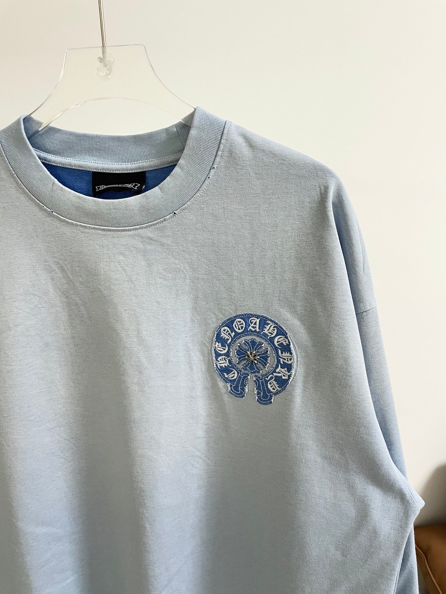 Light blue long-sleeve shirt with blue embroidered elephant-style chest graphic