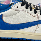 Close-up of white and blue sneaker side with black lace, stitching, and textured panel