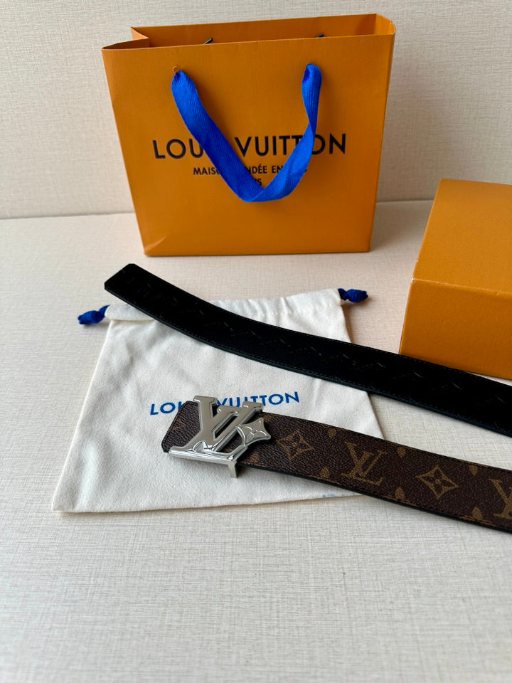 Louis Vuitton monogram belt with dark strap and silver-tone LV buckle on cloth