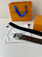 Louis Vuitton monogram belt with dark strap and silver-tone LV buckle on cloth
