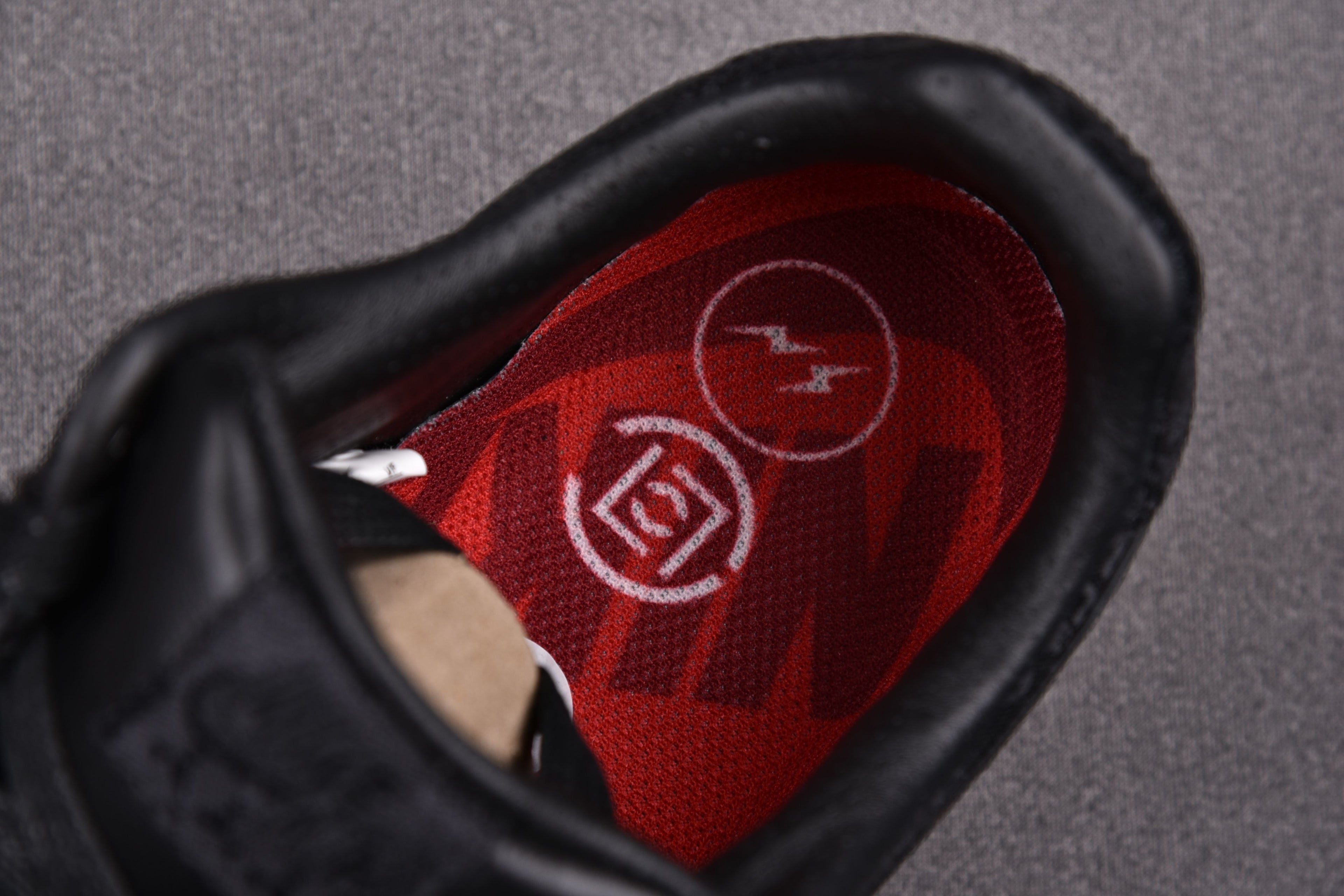 Black sneaker interior with red insole and circular logo