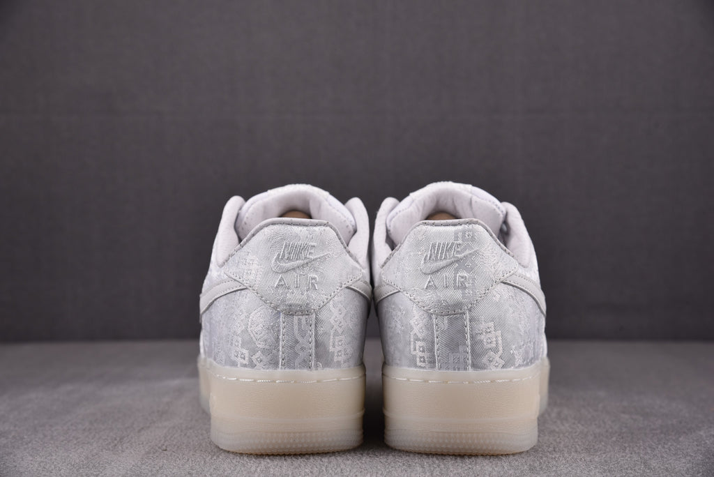 White low-top sneakers heel view with embossed text and lace-up detail